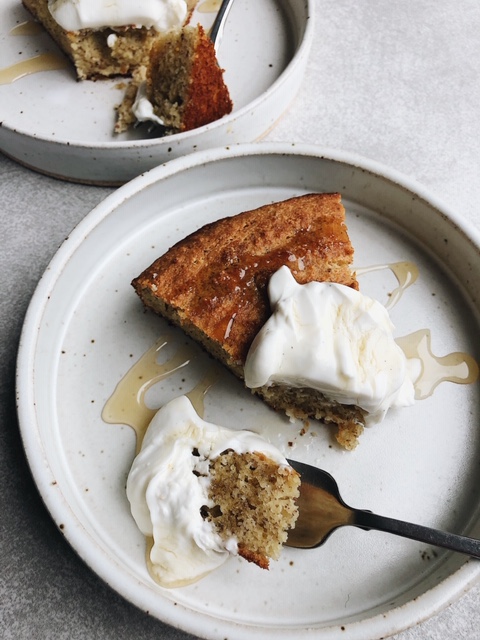 2 slices of cake with dollop of yogurt and drizzle of honey on white plates