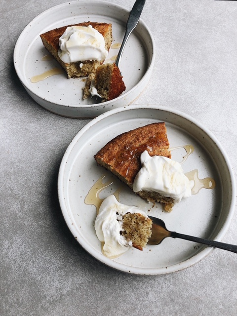 2 slices of cake with dollop of yogurt and drizzle of honey on white plates