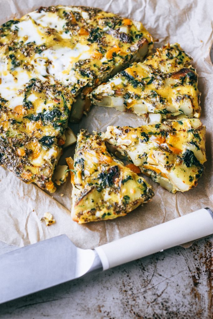 frittata on parchment paper with a knife