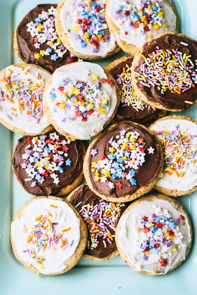 sugar cookies with frosting and sprinkles on a blue tray