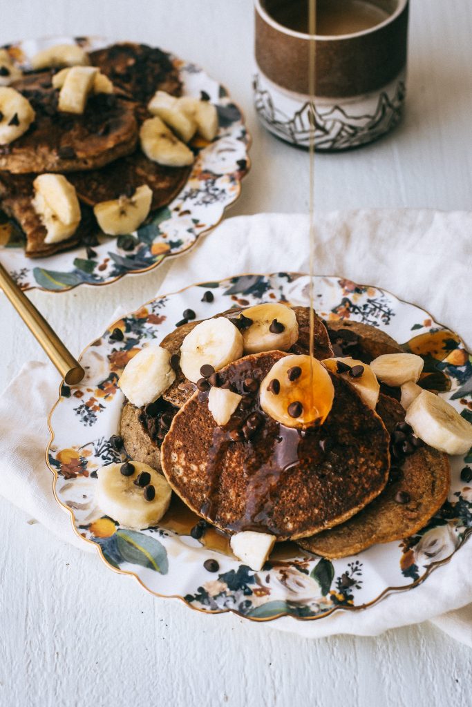 pancakes with bananas and syrup on floral plates