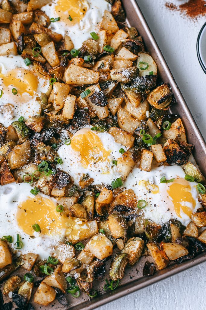 potatoes brussels sprouts and eggs in a baking tray