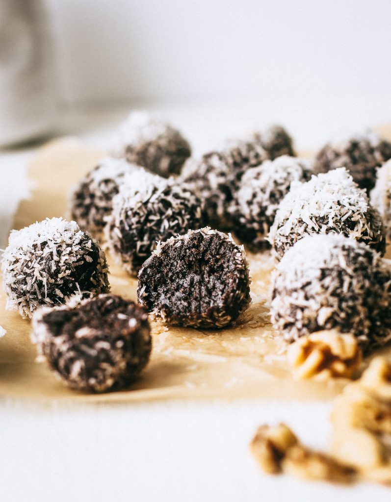 chocolate energy balls rolled in coconut on parchment paper 