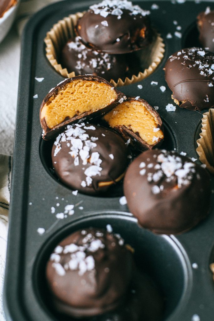 peanut butter chocolate truffles with flaky sea salt in a cupcake tin