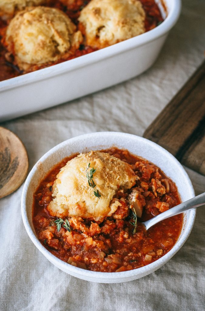 chili with a biscuit in a white bowl