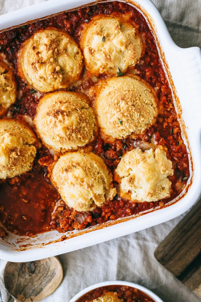 chili topped with biscuits in white baking dish