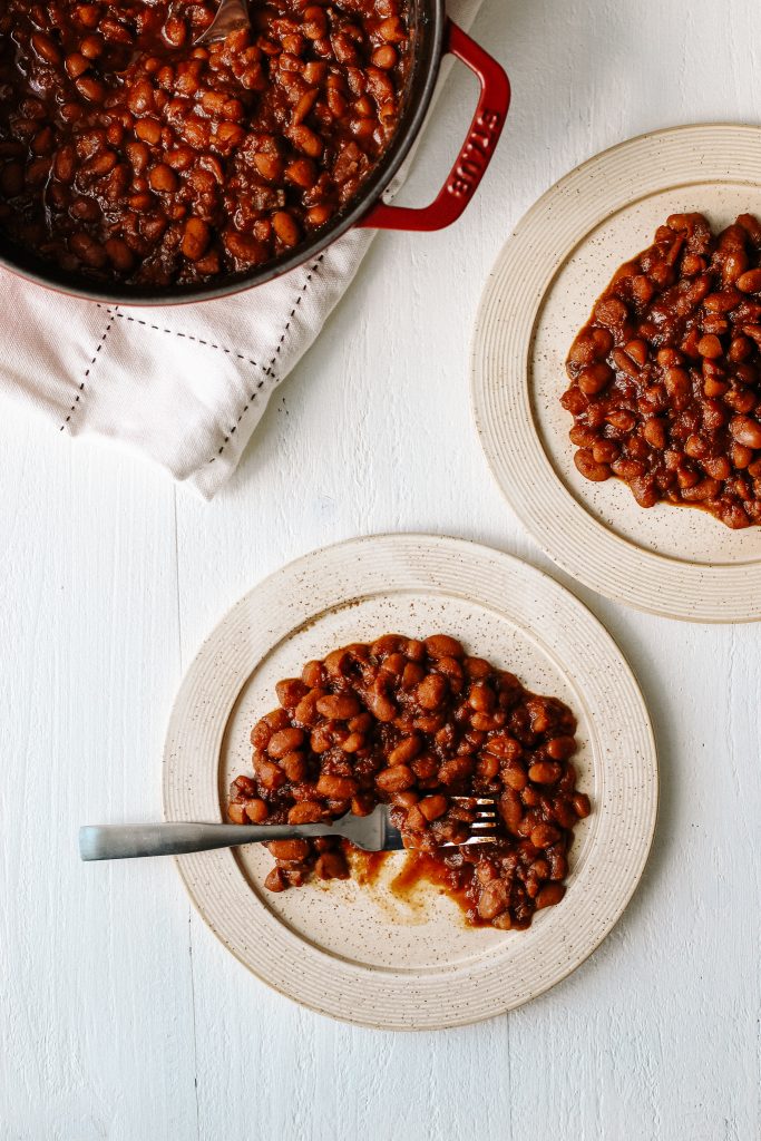 Vegan bbq baked beans on plate with fork and pot of beans
