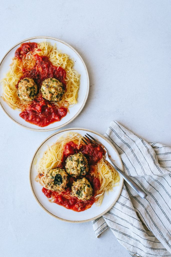 broccoli chicken meatballs with spaghetti squash and marinara on plates 