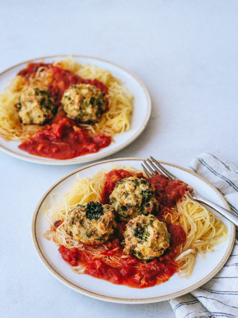 broccoli chicken meatballs with spaghetti squash and marinara on plates 