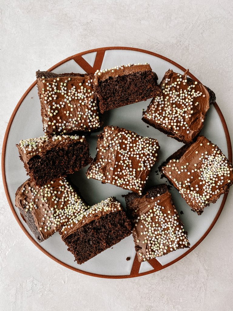 brownies with frosting and sprinkles on a plate