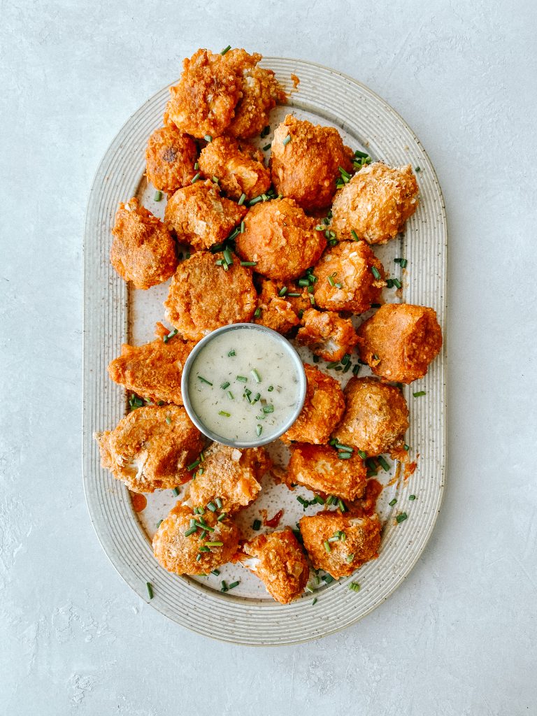 buffalo cauliflower wings on a plate with a small bowl of ranch