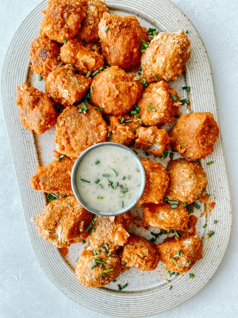 buffalo cauliflower wings on a plate with a small bowl of ranch