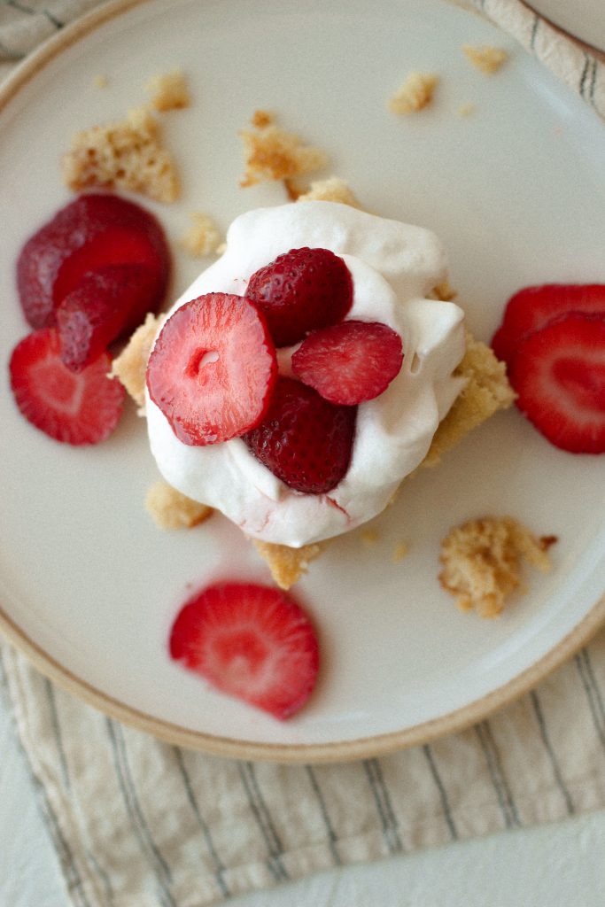 strawberry shortcake with cool whip and strawberries on a plate