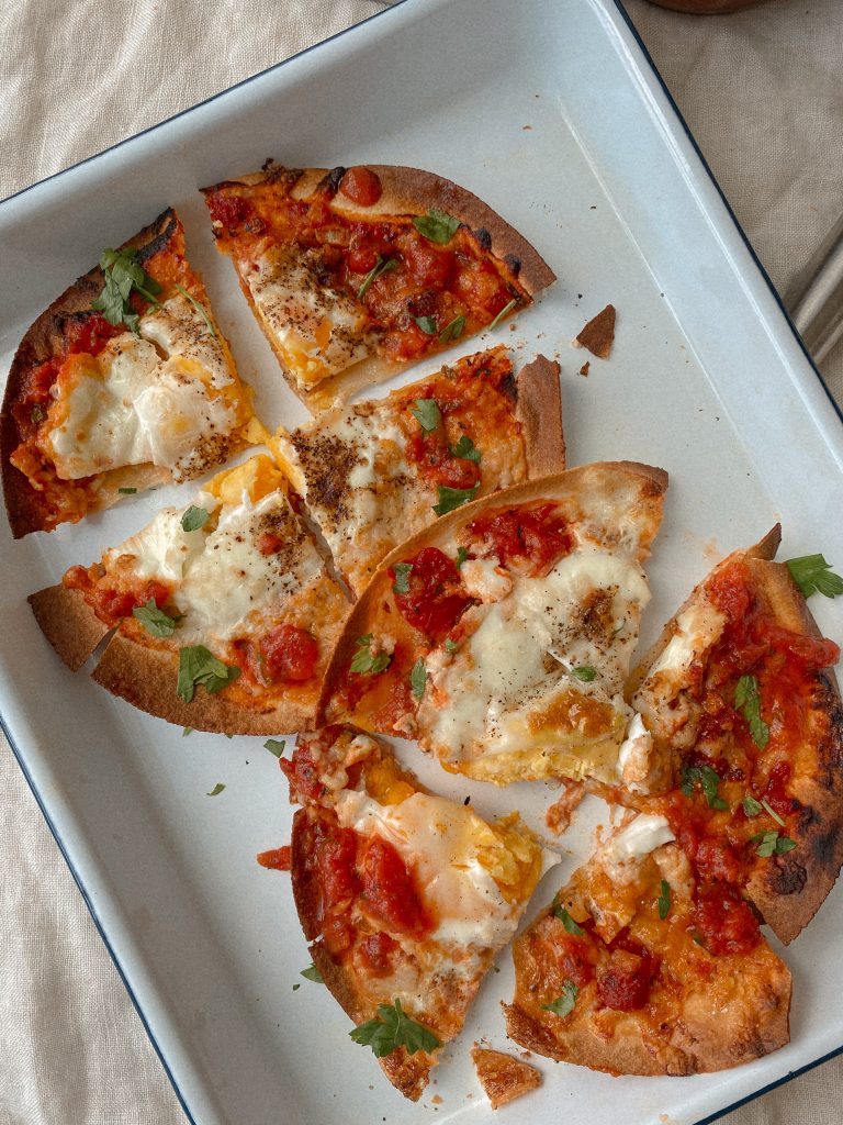 tortilla breakfast pizzas sliced on a white tray