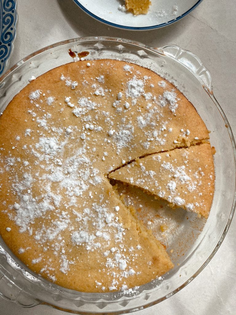 lemon olive oil cake in pie dish with slice missing