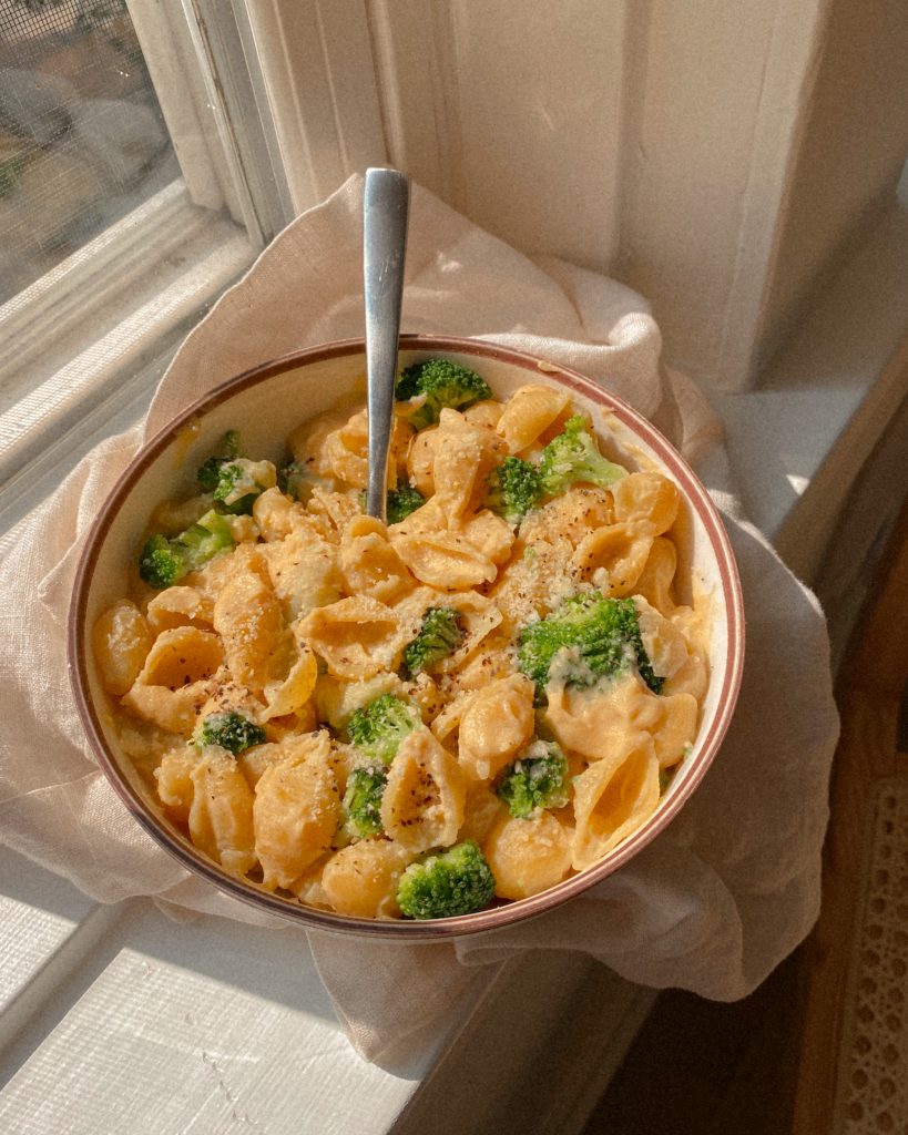 The Best Butternut Squash and Cauliflower Mac and Cheese with broccoli in a bowl on a white towel