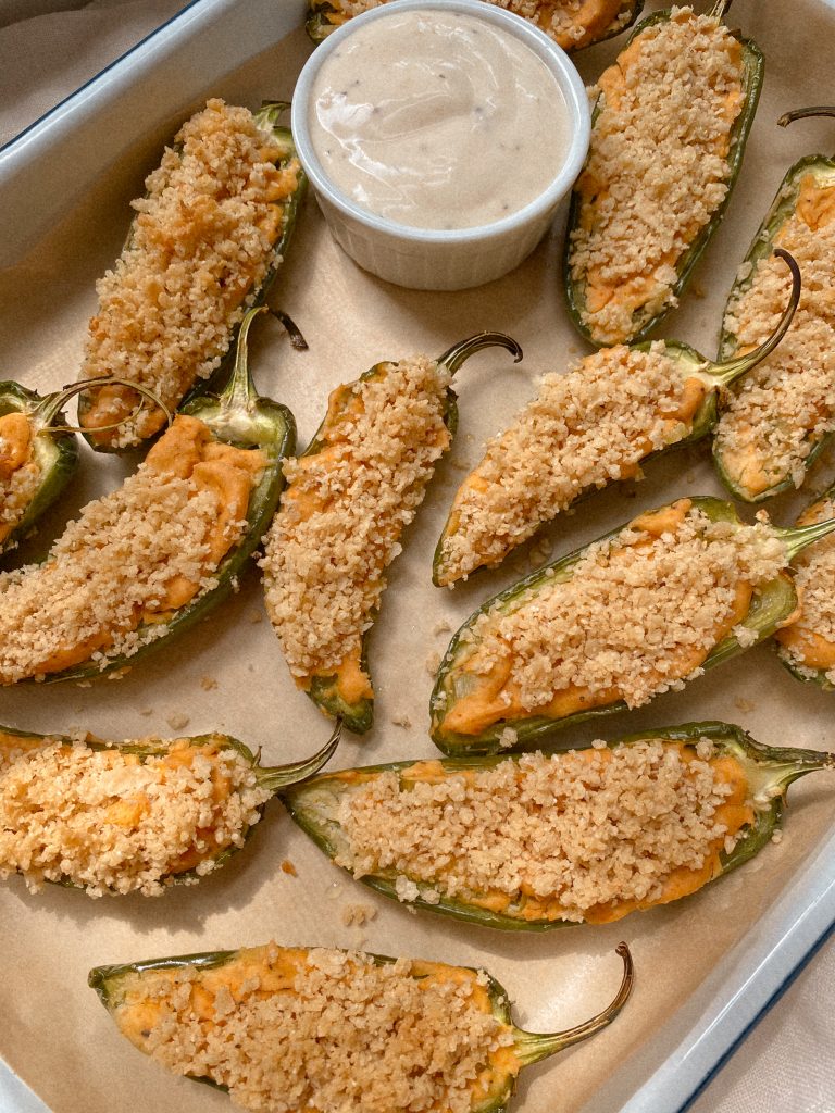 jalapeno poopers with small bowl of ranch on parchmenet paper