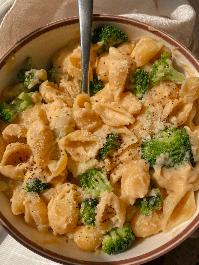 The Best Butternut Squash and Cauliflower Mac and Cheese with broccoli in a bowl on a white towel