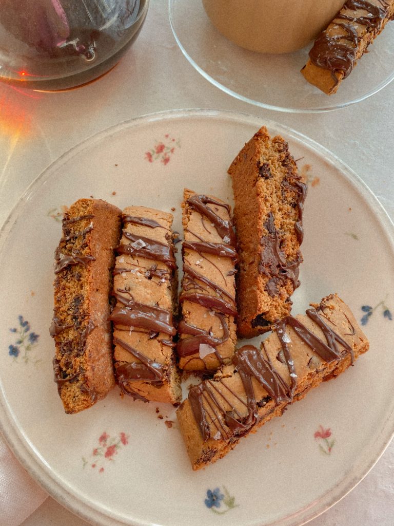 biscotti with chocolate drizzle on floral plate 