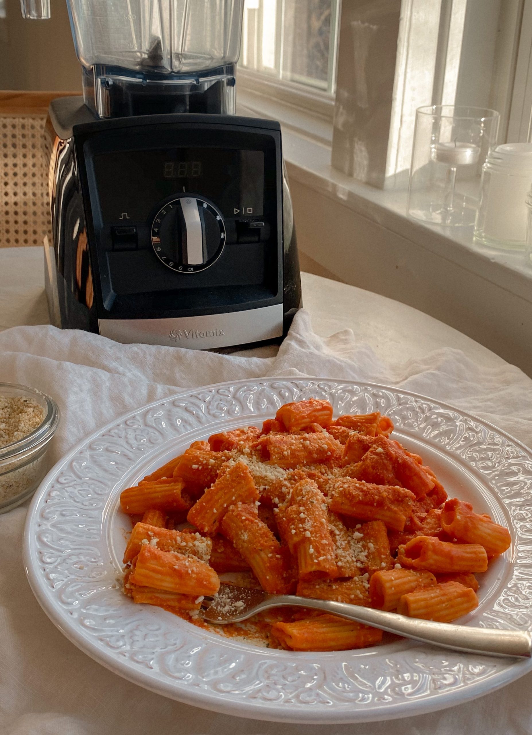 tomato sauce rigatoni pasta on a white plate with a fork