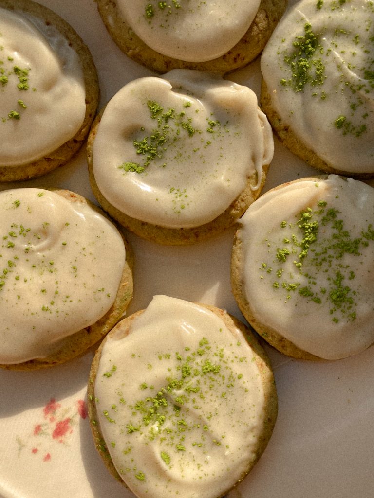 matcha cookies with vanilla frosting on a floral plate
