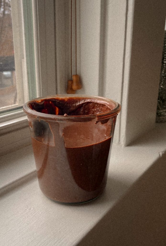 chocolate peanut butter in a jar on a windowsill