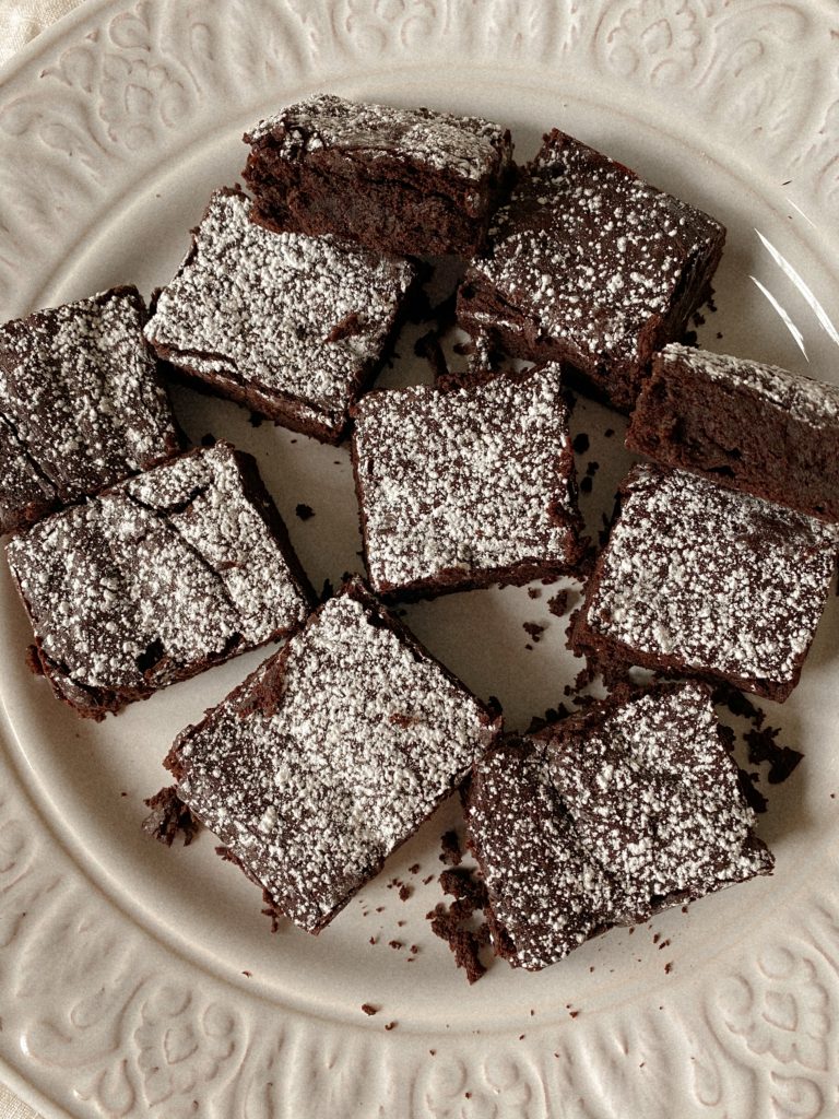 brownies with powdered sugar on a white plate
