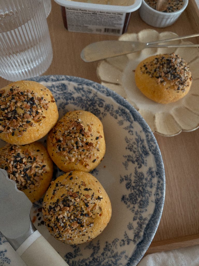 sweet potato dinner rolls with everything bagel seasoning in a blue floral bowl with one on a plate