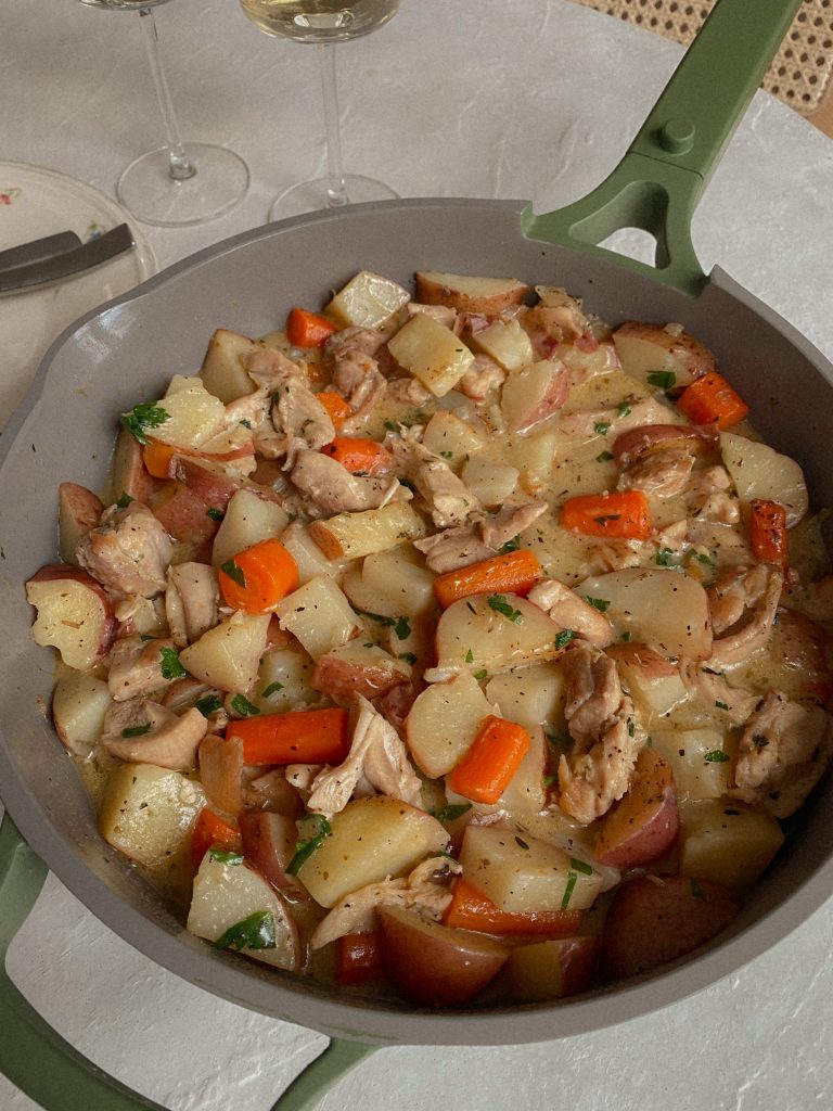 Chicken and Potato Skillet Recipe with carrots, herbs in a skillet on a table. 